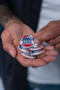 pexels photo 4669146 4669146 Close-up of hands holding patriotic voting pins representing democracy.